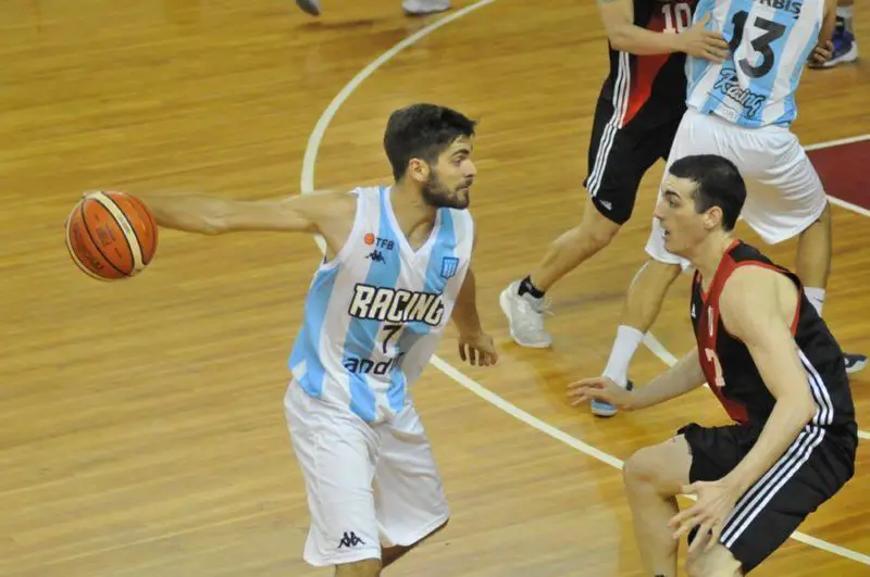 Jugador del basquet de Racing protege la pelota.