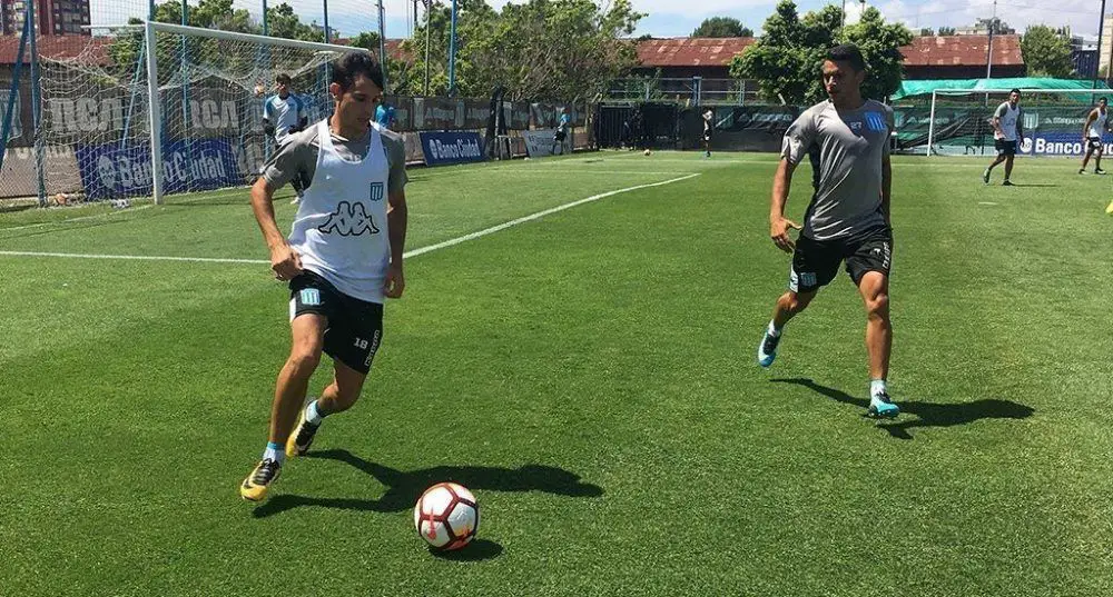 Augusto Solari lleva la pelota ante la presencia de Maxi Cuadra en la cancha auxiliar del Cilindro.